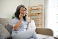 A middle-aged Asian woman enjoys her morning coffee and talking on the phone with her friend Royalty Free Stock Photo