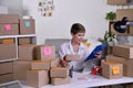 Middle aged Asian woman entrepreneur, Business owner checking address and delivery detail before shipping product
