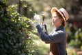 Middle aged asian woman gardener trimming plants in the garden