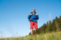 Middle-aged Backpacker traveler looking at sunset and preparing for trekking at summertime sunny day. Active people concept image