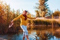 Middle-aged woman walking on river bank on autumn day. Senior lady having fun in the forest enjoying nature Royalty Free Stock Photo