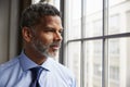 Middle aged black businessman looking out of window