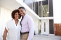 Middle aged African American  couple stand outside looking to camera in front of their modern home, close up Royalty Free Stock Photo