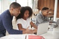 Middle aged African American  man helping his teenage children do their homework using laptop computers Royalty Free Stock Photo