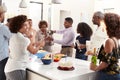 Middle aged African American man pouring champagne to celebrate at home with his three generation family