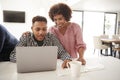 Middle aged African American  mum helping her teenage son do his homework using a laptop, close up Royalty Free Stock Photo