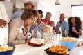 Middle aged African American woman cutting cake during a three generation family birthday celebration,close up