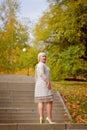 A middle-aged blonde woman of large size poses in a city Park on a staircase on a Sunny autumn day. Royalty Free Stock Photo