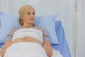 A middle-aged breast cancer patient lay on the bed look at far point with absent minded manner