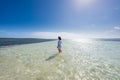 Woman in shallow sea with boat