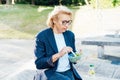 Middle-aged business woman eating salad from her lunch box sitting on the bench at office park. Balanced diet lunchbox Royalty Free Stock Photo