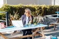 Middle-aged business woman having lunch at the park outdoor cafe, picnic area and working on laptop during her break Royalty Free Stock Photo