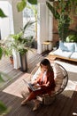 Middle aged business woman using laptop in sunny green office. Vertical. Royalty Free Stock Photo