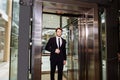 Middle aged businessman with briefcase coming out from elevator Royalty Free Stock Photo