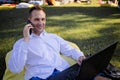 Middle Aged Businessman Sits On Grass Works On Laptop Royalty Free Stock Photo