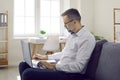 Middle aged businessman working with laptop and making notes Royalty Free Stock Photo