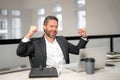 Middle aged businessman working with laptop in office. Hispanic business man using laptop. Excited man using laptop at Royalty Free Stock Photo