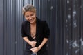 middle-aged businesswoman laughs bending against the background of a gray wall in the office Royalty Free Stock Photo