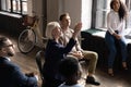 Middle aged businesswoman raising hand, asking question at briefing Royalty Free Stock Photo