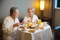 Middle aged couple having breakfast and looking at each other in hotel room Royalty Free Stock Photo