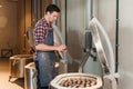 Middle aged caucasian male potter in apron counts clay pots before firing in the oven during work day in the pottery Royalty Free Stock Photo