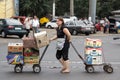 Middle aged caucasian woman showing efforts pulling a cart in the privoz central market of Odessa