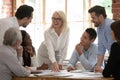 Middle aged boss and company staff discuss project at meeting