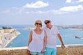 Middle-aged couple of baby boomers people posing for photograph opposite blue sea