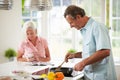 Middle Aged Couple Cooking Meal In Kitchen Together Royalty Free Stock Photo