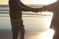 Middle-aged couple dancing at sunset at seashore