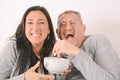 Middle-aged couple eating popcorn and watching a movie Royalty Free Stock Photo