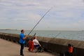 Middle aged couple fishing on the seawall of Samphire Hoe, Dover