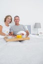 Middle aged couple having breakfast in bed together Royalty Free Stock Photo