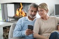 Middle-aged couple having fun on smartphone Royalty Free Stock Photo