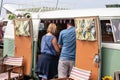 A middle aged couple looking into a camper van