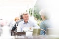 Middle-aged couple sitting at sidewalk cafe on sunny day Royalty Free Stock Photo