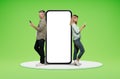 Middle aged couple standing by big phone with white screen Royalty Free Stock Photo