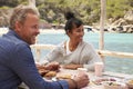 Middle aged couple at table by the sea looking at each other Royalty Free Stock Photo