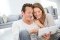 Middle-aged couple with tablet websurfing at home Royalty Free Stock Photo