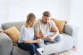 Middle-aged couple wearing casual clothes and sitting at home on the sofa and using a laptop Royalty Free Stock Photo