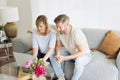 Middle-aged couple wearing casual clothes and sitting at home on the sofa and using a laptop Royalty Free Stock Photo