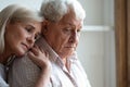 Middle-aged daughter snuggle to elderly father sharing his sorrows