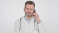 Middle Aged Doctor Talking on Smartphone, White Background Royalty Free Stock Photo