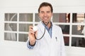 Middle aged doctor using his stethoscope. He is at the clinic Royalty Free Stock Photo