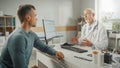 Middle Aged Family Doctor is Talking with Young Male Patient During Consultation in a Health Clinic Royalty Free Stock Photo