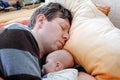 Middle aged father sleeping near his newborn baby daughter Royalty Free Stock Photo