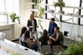 Middle-aged female boss teaching young specialists during informal briefing Royalty Free Stock Photo