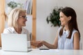 Aged employer congratulates young woman with job interview successful accomplishment