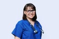 Middle aged female nurse in blue uniform with stethoscope smiling looking at camera Royalty Free Stock Photo