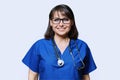 Middle aged female nurse in blue uniform with stethoscope smiling looking at camera Royalty Free Stock Photo